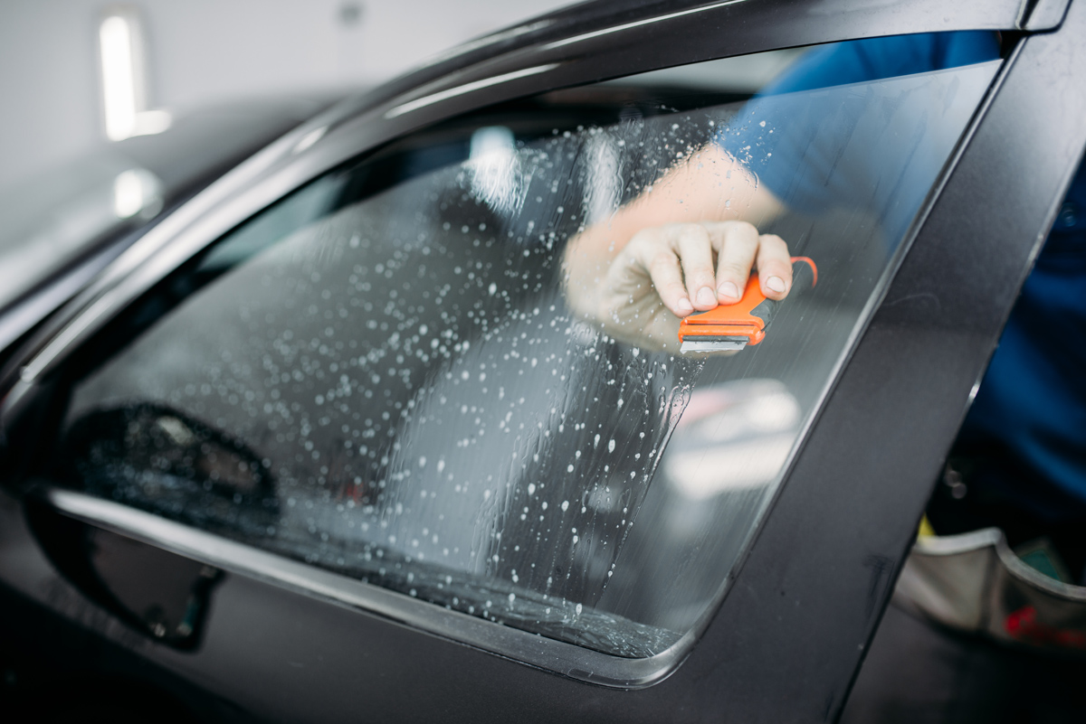 Specialist tinting a car window